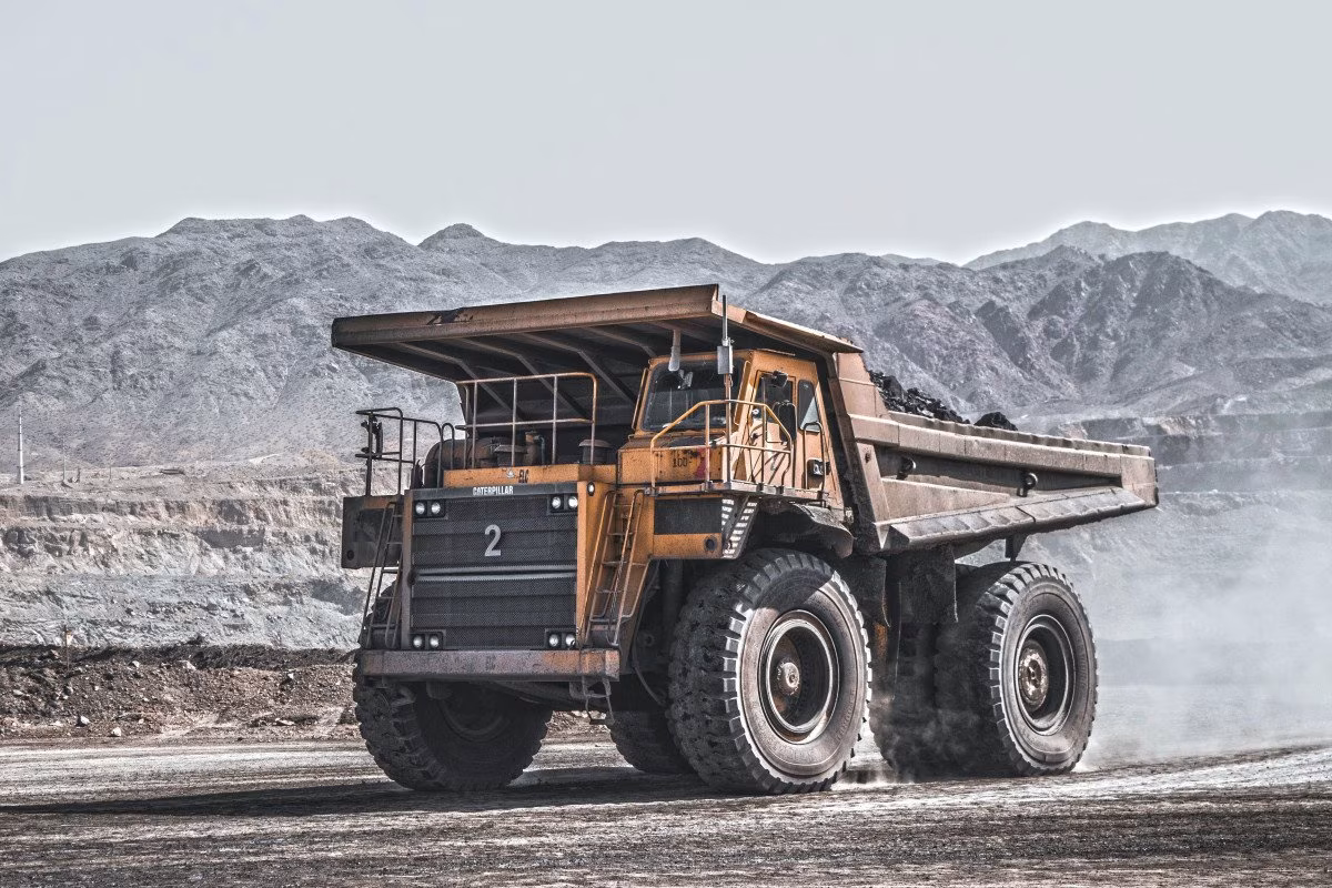 Yellow Caterpillar mining truck with the number 2 on its grille, in a dusty open-pit mine. from Stockmark.it