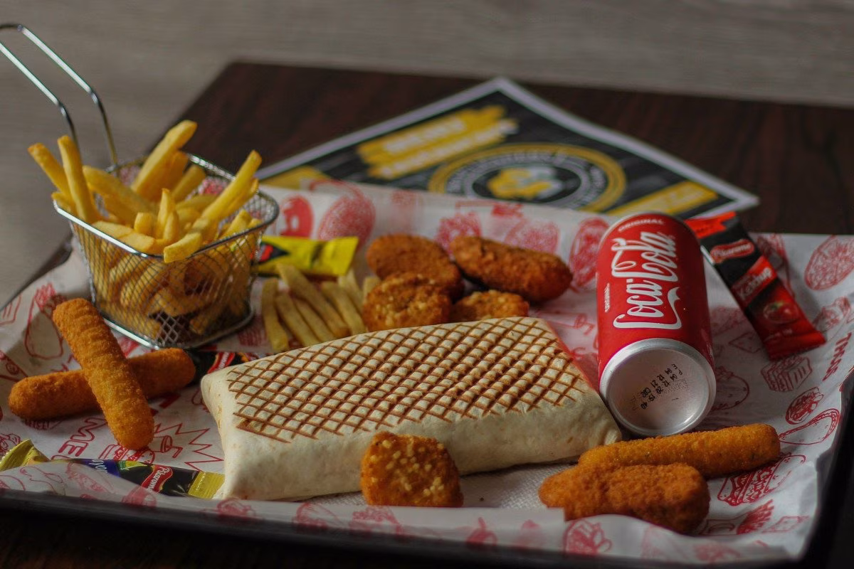 Fast food meal with tacos, fries, and chicken nuggets, Coca-Cola can from Stockmark.it