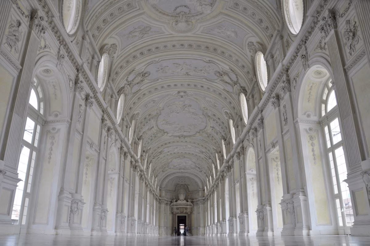 Grand ornate white palace interior with long hall and arched windows from Stockmark.it