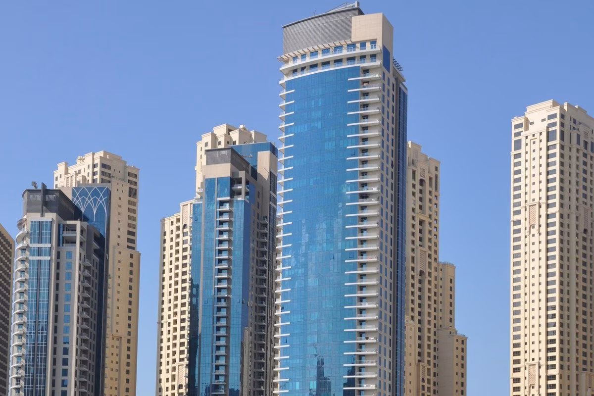 Modern skyscrapers in a city skyline, possibly Dubai, against a clear blue sky. from Stockmark.it