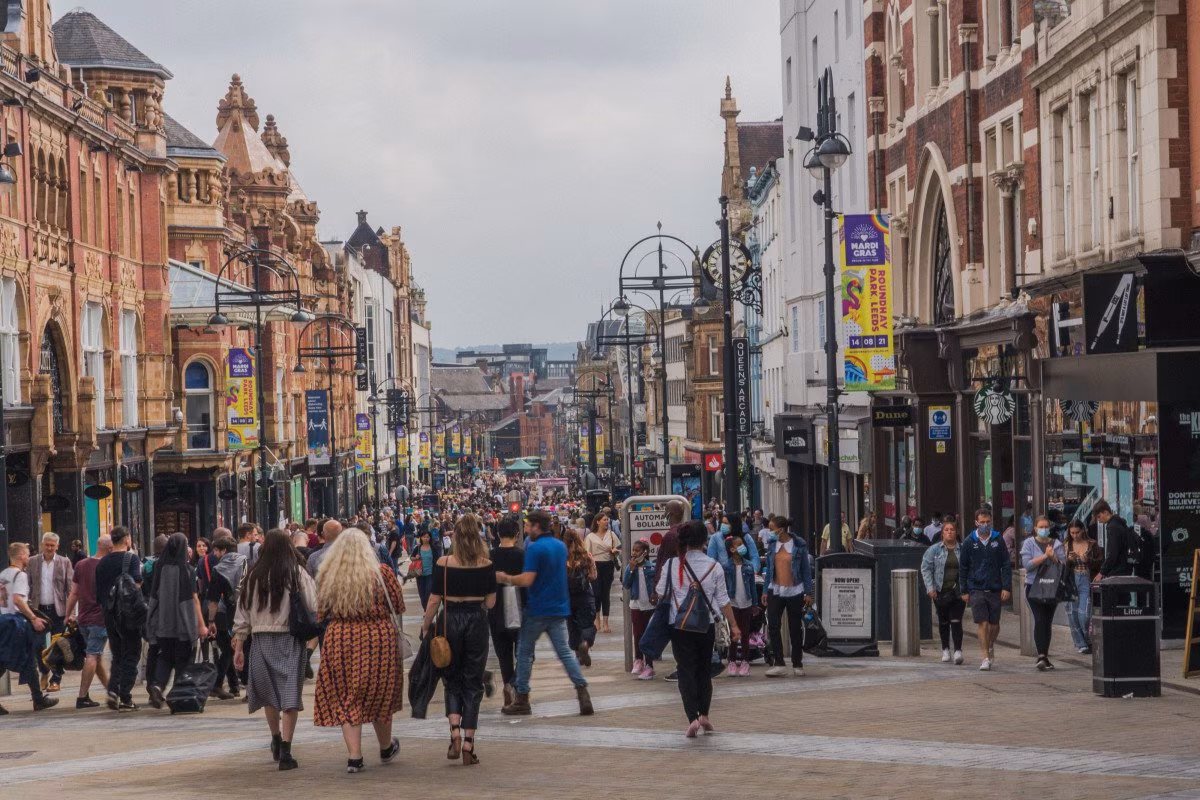 Crowded UK high street with shops and pedestrians, reflecting property tax burdens. from Stockmark.it