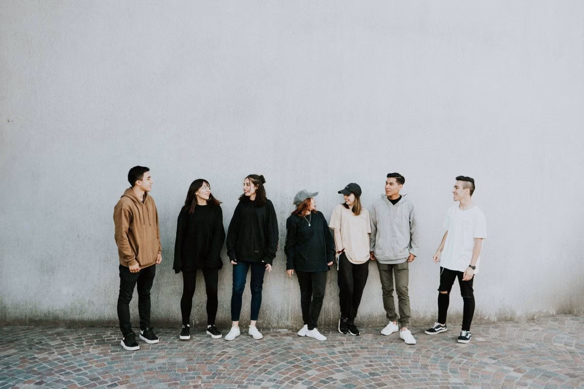 Diverse group of young people standing against a wall, representing youth unemployment in Britain. from Stockmark.it