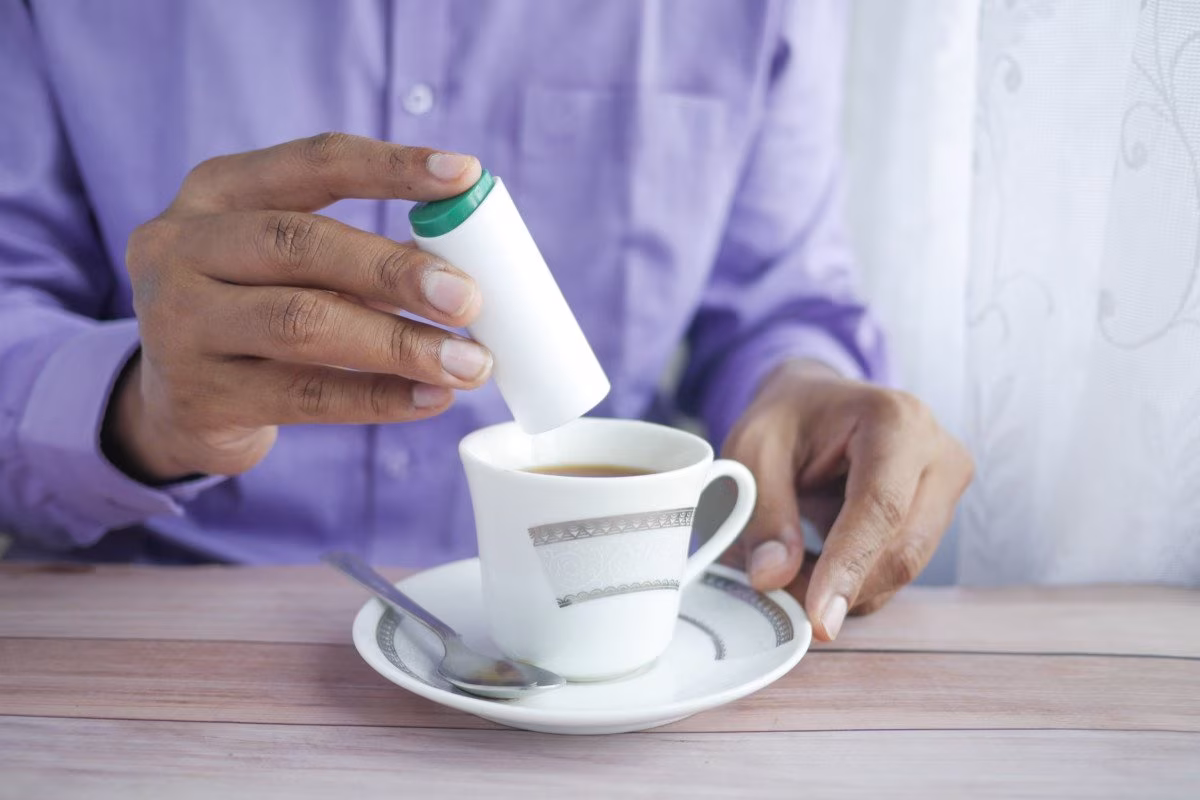 Person adding sweetener to a cup of tea, Tate & Lyle acquired by Ingredion from Stockmark.it