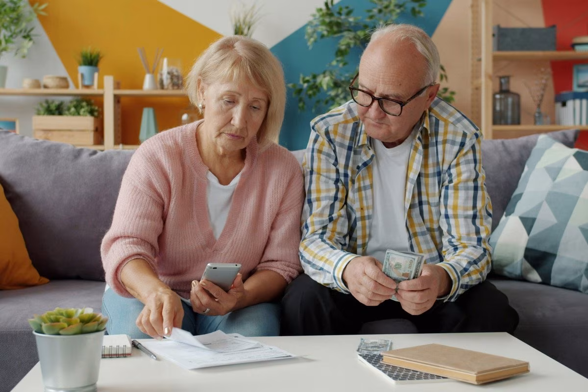 Elderly couple reviewing finances, potentially for family support for first-time home buyers. from Stockmark.it
