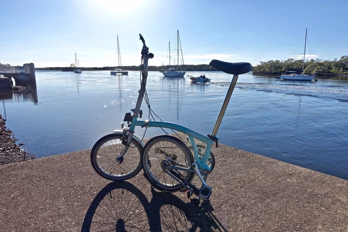 Light blue Brompton folding bike on a concrete pier by the water. from Stockmark.it