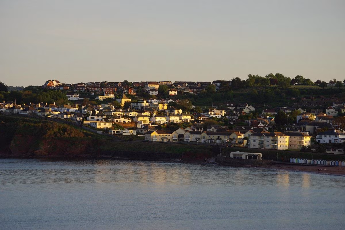 Coastal town with houses on a hill overlooking the sea at sunset. from Stockmark.it